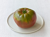 Black polish tomato on white plate