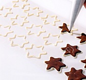 Close-up of chocolate being filled into stars with piping bag for decoration step 2