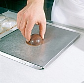 Press halved chocolate egg on hot plate, step 6