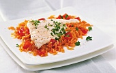 Close-up of cod fillet with tomato rice and parsley garnished on it