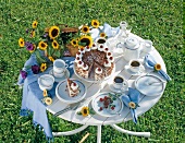 Table with coffee, cake, dishes and sunflowers