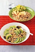 Two bowls of oat muesli with coconut, grapes, apples and kiwi fruit