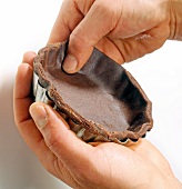 Close-up of hand putting pastry dough in mould, step 1