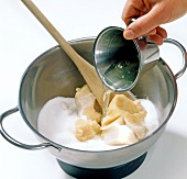 Close-up of liquid being poured in sugar-marzipan mixture, step 1