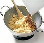 Close-up of rubbed chocolate being added in mixture, step 2