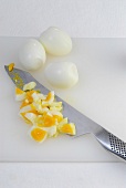 Boiled eggs being diced on chopping board, step 3
