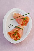 Two salmon parcels with chives on dish