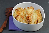 Bowl of pancakes with veal filling on gray background