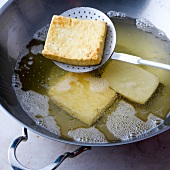 Close-up of tofu being fried in pan, step 2