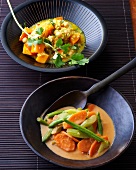 Pumpkin and chickpea curry and vegetables in peanut sauce in bowls