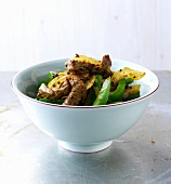 Beef with peppers, onions and brown mustard seeds in bowl