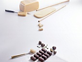 Raw marzipan and chocolates on white background