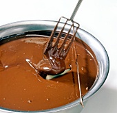 Marzipan chocolate being dipped in chocolate with fork, step 1