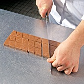 Close-up of chef cutting pralines into triangles, step 3