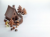 Chocolates in the form of witch house and fir tree on white background