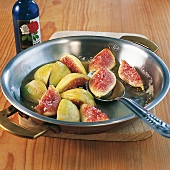 Close-up of bowl of figs in honey glaze on wooden board