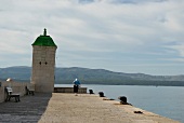 Pier in Brac, Bick aufs Meer und Gebirge, Wolken am Himmel.