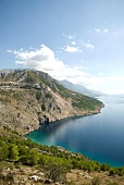 View of rocky sea coast, mountains and blue sky in Dalmatia, Croatia
