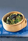 Steamed salmon fish with Chinese cabbage and leeks in steamer basket
