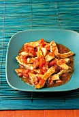 Sweet and sour pork with tomatoes and shallots in serving dish