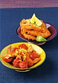 Veal cutlets with lemon and shrimp with tomatoes in bowls