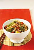 Mie noodles with sugar snap peas and cherry tomatoes in bowl