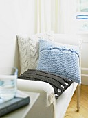 Three knitted cushions on large chair