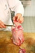 Chef pushing down the meat with knife