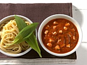 Spaghetti with tomato, herb sauce and mozzarella in bowls 