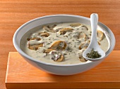 Sauce in bowl made of mushroom, cream, thyme on wooden board