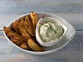 Potato wedges with herb sour cream in bowl