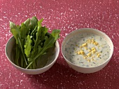 Two bowls with feta and lemon dressing and arugula leaves