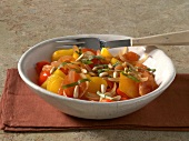 Bowl of spicy peperonata with pine nuts and peppers