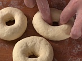 Dough being shaped for preparation of sesame bagel, step 3