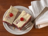 Two pieces of trifle cake with eggnog and cherries