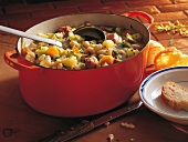 Suppen, Gemüseeintopf mit Flei sch, Brot, weiße Bohnen, roter Topf