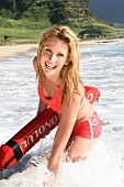 Frau blond am Strand, im Wasser, im roten Bikini