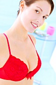 Portrait of beautiful brunette woman wearing red lace bra, smiling