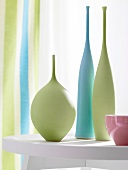 Green, blue and pink porcelain vases on table