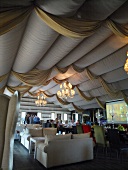 People in restaurant decorated with canopy and chandelier