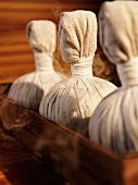 Close-up of smoke coming out of small white sacks containing herbal products 