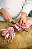 Pork chops being cut from a rack