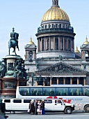Facade of Isaac's Cathedral with golden dome and busy street in St. Petersburg, Russia