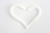 Heart shaped formed with toothpaste on white background