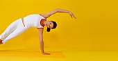 Pilates - Side Bend: Frau auf linken Arm gestützt, Seitenbiegung