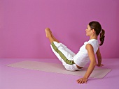 Pilates - Hip Twist: Frau sitzt Beine nach links ziehen, Step 2b