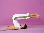 Pilates - Boomerang: Frau, Beine gestreckt über Kopf ziehen, Step 3