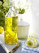 Lemon oil with thyme and lemon peel in bottle