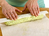 Herbal butter being rolled in baking paper, step 4