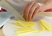 Ginger being cut into strips with knife, step 5